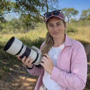 Professional safari guide Tayla McCurdy holds a long lens camera